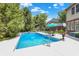 Inviting backyard pool featuring lush landscaping and poolside furniture, ideal for summer relaxation and outdoor enjoyment at 4704 Pearcrest Way, Greenwood, IN 46143