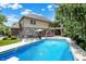 Beautiful backyard pool with sprayers next to a brick home with a pergola, surrounded by lush greenery at 4704 Pearcrest Way, Greenwood, IN 46143