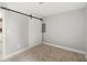 Small, unfurnished bedroom features a barn door closet and neutral decor at 4904 E 14Th St, Indianapolis, IN 46201