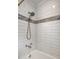 Renovated bathroom features modern shower head, white subway tile with gray accents at 5660 Crittenden Ave, Indianapolis, IN 46220