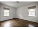 Bright bedroom offers hardwood floors, two windows with roller shades, and neutral walls at 5660 Crittenden Ave, Indianapolis, IN 46220