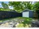 Backyard view of the garage and privacy fence with mature trees and green grass at 5660 Crittenden Ave, Indianapolis, IN 46220