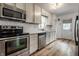 Modern kitchen with stainless steel appliances, white cabinets, and a subway tile backsplash at 5660 Crittenden Ave, Indianapolis, IN 46220