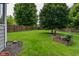 Expansive backyard with manicured lawn, privacy fence, mature trees, and a planter at 6118 Yellow Birch Ct, Avon, IN 46123