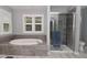 Bathroom featuring a soaking tub, a tiled shower, and a window with shutters at 6118 Yellow Birch Ct, Avon, IN 46123