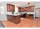 Open kitchen featuring wooden cabinetry, stainless steel appliances, granite countertops, and hardwood floors at 6118 Yellow Birch Ct, Avon, IN 46123