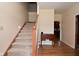 Carpeted staircase leading to the upper level, complemented by hardwood flooring and a nearby console table at 6118 Yellow Birch Ct, Avon, IN 46123