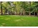 Spacious backyard with lush green lawn surrounded by mature trees, creating a private and serene setting at 6280 N Chester Ave, Indianapolis, IN 46220