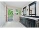 Bathroom with a black double vanity, patterned tile flooring, and access to the outdoor deck at 6280 N Chester Ave, Indianapolis, IN 46220
