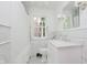 All white bathroom with marble finishes, vintage mirror and window at 6280 N Chester Ave, Indianapolis, IN 46220