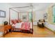 Bedroom with canopy bed, window with shutters, and hardwood floors at 6280 N Chester Ave, Indianapolis, IN 46220