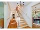 Bright foyer featuring hardwood floors, staircase with white railings, and elegant chandelier lighting at 6280 N Chester Ave, Indianapolis, IN 46220