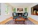 Cozy living room with a fireplace, hardwood floors, two chairs, and bright windows at 6280 N Chester Ave, Indianapolis, IN 46220