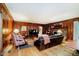 Cozy living room featuring wood paneling, a brick fireplace and comfortable furnishings at 6280 N Chester Ave, Indianapolis, IN 46220