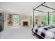 Bright main bedroom with built in shelving, brick fireplace, and window seat overlooking lush greenery at 6280 N Chester Ave, Indianapolis, IN 46220