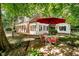 Outdoor patio with a red umbrella, a round table, and seating for four on a brick-paved area at 6280 N Chester Ave, Indianapolis, IN 46220