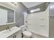 Bathroom features a vanity with a mirror, toilet, and shower tub with a small window at 629 E 25Th St, Indianapolis, IN 46205