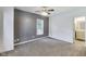 The bedroom has neutral carpet, a gray accent wall and standard ceiling fan with lights at 629 E 25Th St, Indianapolis, IN 46205