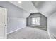 Bedroom has neutral carpet, gray walls, sloped ceiling, and window for natural light at 629 E 25Th St, Indianapolis, IN 46205