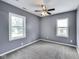 Bedroom with two windows, neutral carpet and gray walls, offering abundant natural light at 629 E 25Th St, Indianapolis, IN 46205
