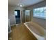 Primary bathroom features a soaking tub, a glass shower, a view of a window and a view of the entrance to a bedroom at 6632 Coppel Ct, Indianapolis, IN 46259