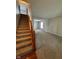 A view of stairs leading upstairs and a carpeted living room with adjacent dining room at 6632 Coppel Ct, Indianapolis, IN 46259