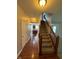 Carpeted staircase with wooden banister leading up to a large landing with hardwood flooring in the entry area at 6632 Coppel Ct, Indianapolis, IN 46259