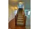 Carpeted staircase with wooden banister leading to the upper level, complemented by hardwood flooring in the entry area at 6632 Coppel Ct, Indianapolis, IN 46259