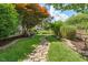 A charming backyard featuring a stone pathway winding through lush greenery and landscaping at 718 E Washington St, Lebanon, IN 46052