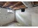A basement with unfinished walls, a small window, and visible ceiling beams at 718 E Washington St, Lebanon, IN 46052