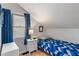 Quaint bedroom has a slanted ceiling, blue curtains and a bright window view at 718 E Washington St, Lebanon, IN 46052