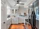 Well-lit kitchen boasts white cabinets, stainless steel appliances, hardwood floors, and an opening to the dining area for convenient serving at 718 E Washington St, Lebanon, IN 46052