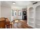 Sun-filled living room with bay windows, hardwood floors, built-in shelving, and a classic piano, offering a welcoming atmosphere at 718 E Washington St, Lebanon, IN 46052