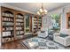Bright living room with built-in bookshelves, cozy seating, and a large window overlooking the outdoors at 718 E Washington St, Lebanon, IN 46052