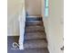 A carpeted staircase with white railing leading to the next level of the house at 7529 N Green Meadows, Fairland, IN 46126