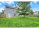 Spacious backyard features a large grassy area, mature tree and wooden fence at 8212 Twin River Dr, Indianapolis, IN 46239