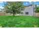 Well-maintained backyard featuring a large tree, green lawn, and a privacy fence at 8212 Twin River Dr, Indianapolis, IN 46239