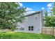 Exterior featuring vinyl siding, lush green grass, and mature trees at 8212 Twin River Dr, Indianapolis, IN 46239