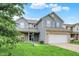 Charming two-story home featuring blue siding, brick accents, well-manicured lawn, and an attached two-car garage at 8212 Twin River Dr, Indianapolis, IN 46239