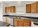 Well-lit kitchen featuring wood cabinets, stainless steel dishwasher, and functional layout with natural light at 8212 Twin River Dr, Indianapolis, IN 46239