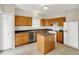 Functional kitchen features wood cabinets, stainless steel dishwasher, white appliances, and a convenient center island at 8212 Twin River Dr, Indianapolis, IN 46239