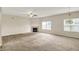 Spacious living area showcasing neutral carpet, fireplace, chandelier lighting, and a ceiling fan at 8212 Twin River Dr, Indianapolis, IN 46239