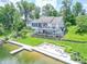 Stunning backyard showcasing a lakefront property with a large deck, patio, and private dock at 9172 W Tulip Dr, Columbus, IN 47201