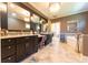 Bright bathroom featuring double sinks, a vanity, elegant chandeliers and a marble tiled floor at 9172 W Tulip Dr, Columbus, IN 47201