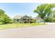 Well-manicured front lawn with a stone-clad house, a large tree and a driveway leading to a garage at 9172 W Tulip Dr, Columbus, IN 47201