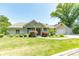 Inviting front exterior featuring stone accents, a well-manicured lawn, and a three car garage at 9172 W Tulip Dr, Columbus, IN 47201