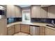 This charming kitchenette features stone countertops, tile backsplash, and stainless steel dishwasher at 9172 W Tulip Dr, Columbus, IN 47201