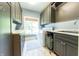 Well-organized laundry room with gray cabinets, a large window, counter space and included washer/dryer at 9172 W Tulip Dr, Columbus, IN 47201