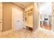 Mudroom featuring tile floors, a built-in bench, storage cabinets, and access to the living room at 9172 W Tulip Dr, Columbus, IN 47201