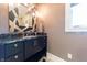 Stylish powder room showcasing granite counters, modern fixtures, and a decorative mirror with lighting at 9172 W Tulip Dr, Columbus, IN 47201